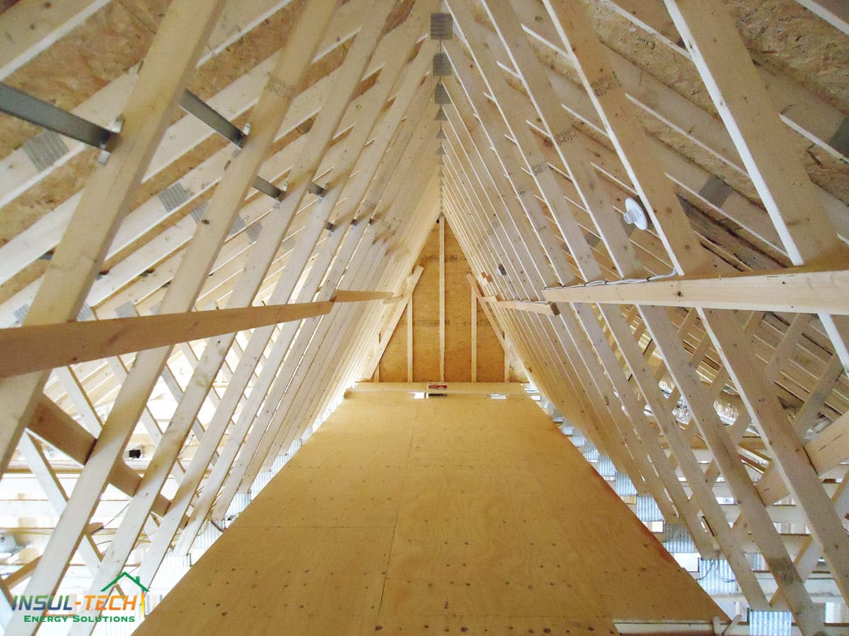 A close up view of the inside of a roof with wooden rafters and a flat platform