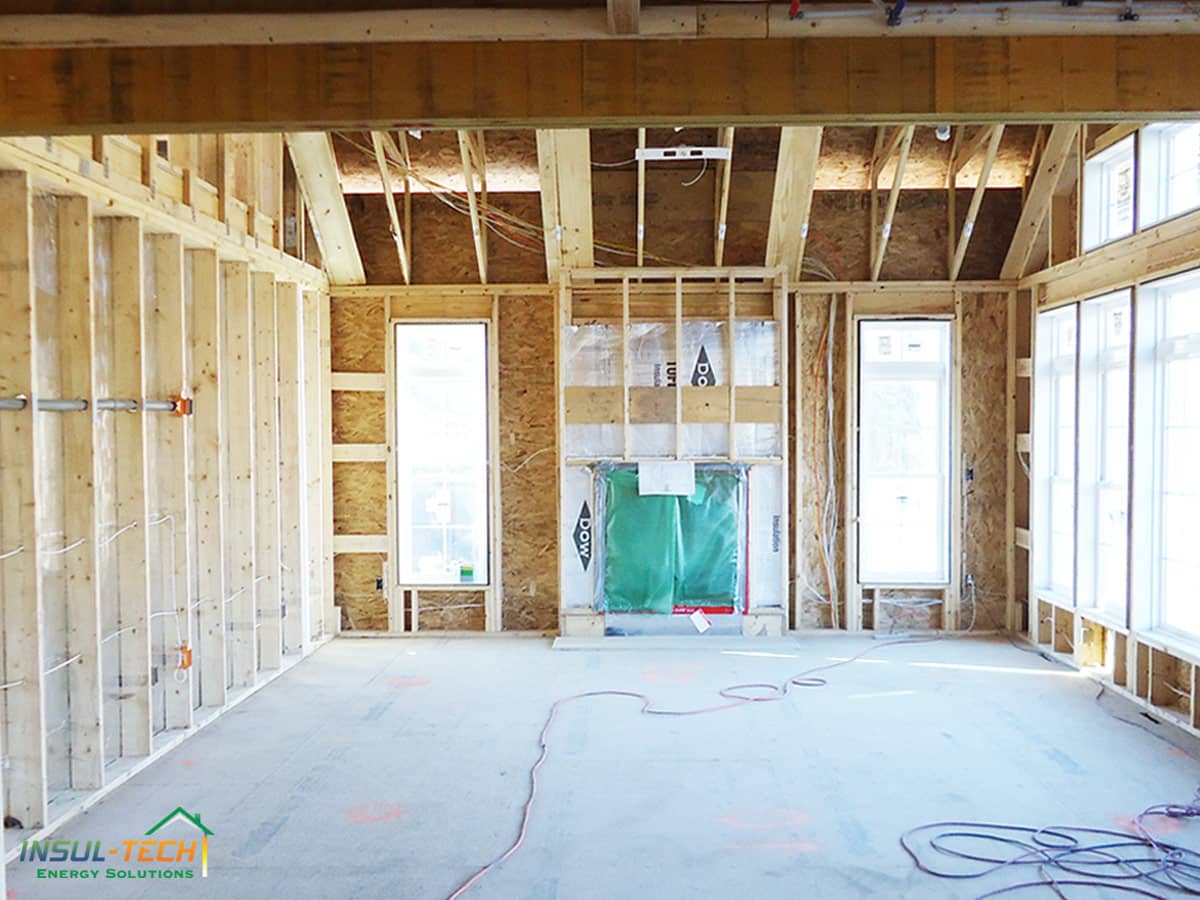 An empty room being built with wooden walls and beams exposed